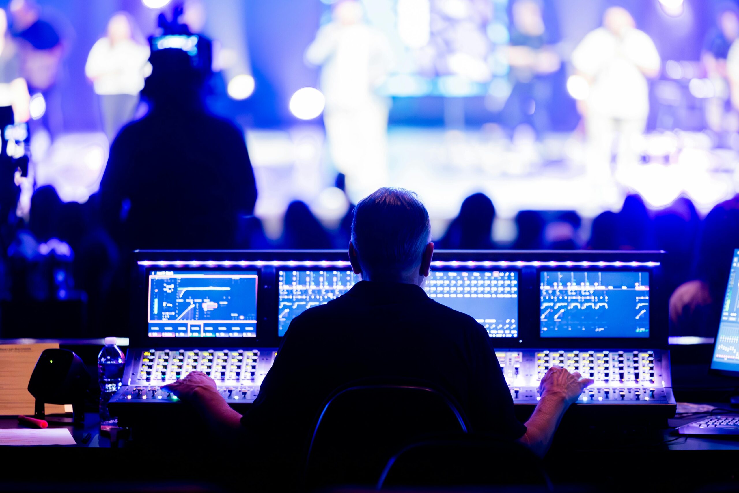 Sound engineer operating a digital mixing console during a live concert performance.